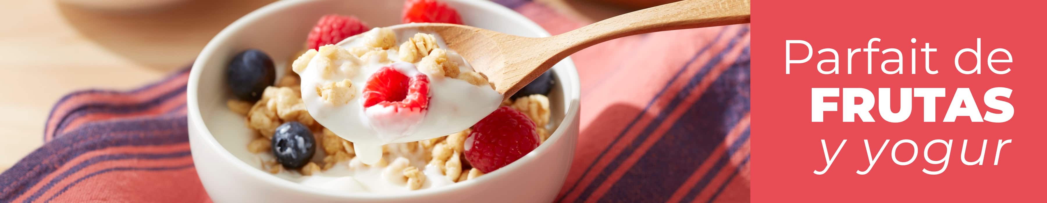 Ingredientes sobre una encimera para hacer vasitos de yogur cremoso con frutas. Muesli, frutas de temporada, yogur estilo griego cremoso, miel y hierbabuena.